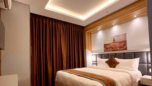 A modern hotel room with a large bed, wooden flooring, and a ceiling light fixture. - Hotel Alleyway Express (Kathmandu)