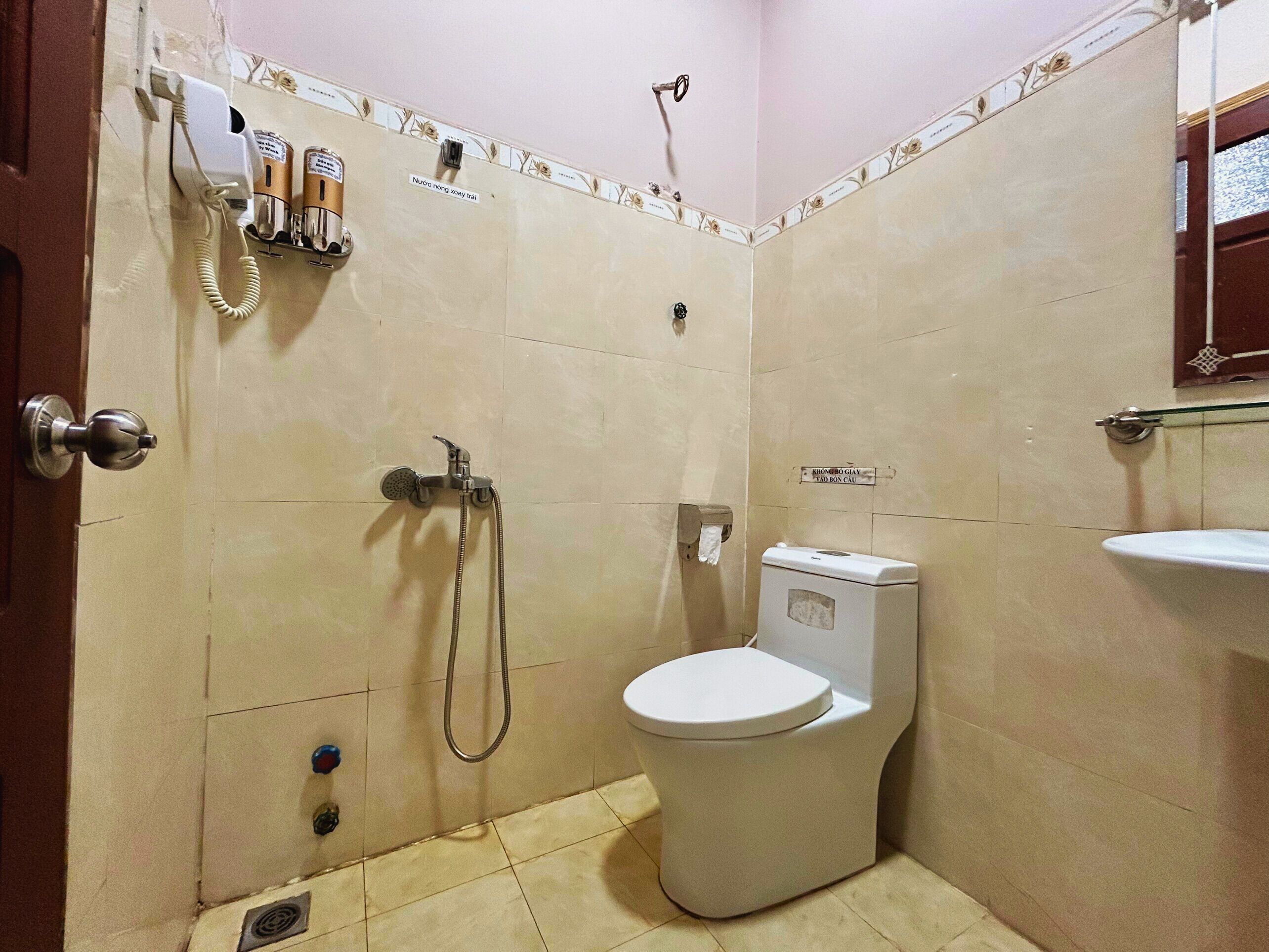 Un baño pequeño con inodoro, ducha y lavamanos empotrado.