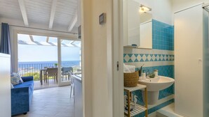 Un baño moderno con lavamanos, espejo e inodoro con ducha.