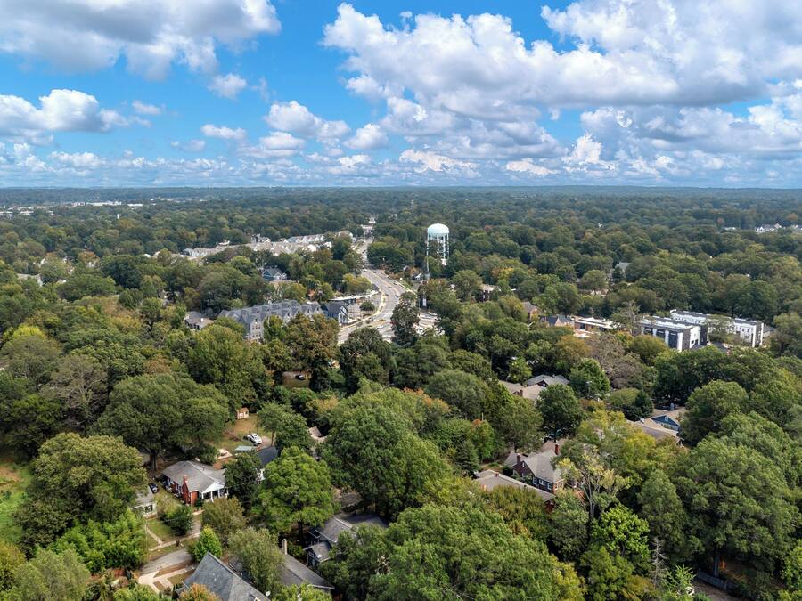 An aerial view of a residential area with houses, a water tower, and a church.
