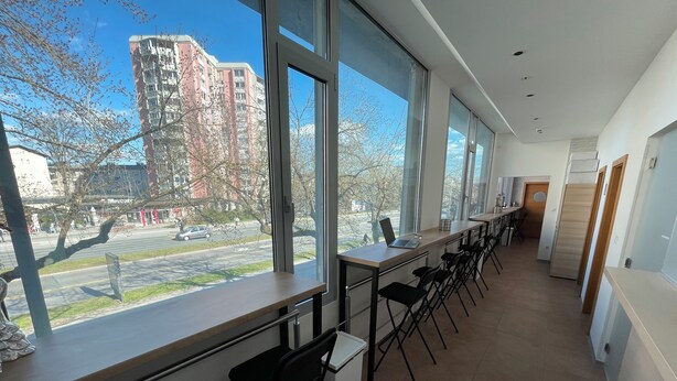 A modern hotel room with large windows, a long dining table, and black chairs. - Sleep&Go Hostel (Ljubljana)