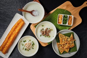 A variety of dishes including a bowl of soup, a fried item, and some flatbreads on a wooden board.