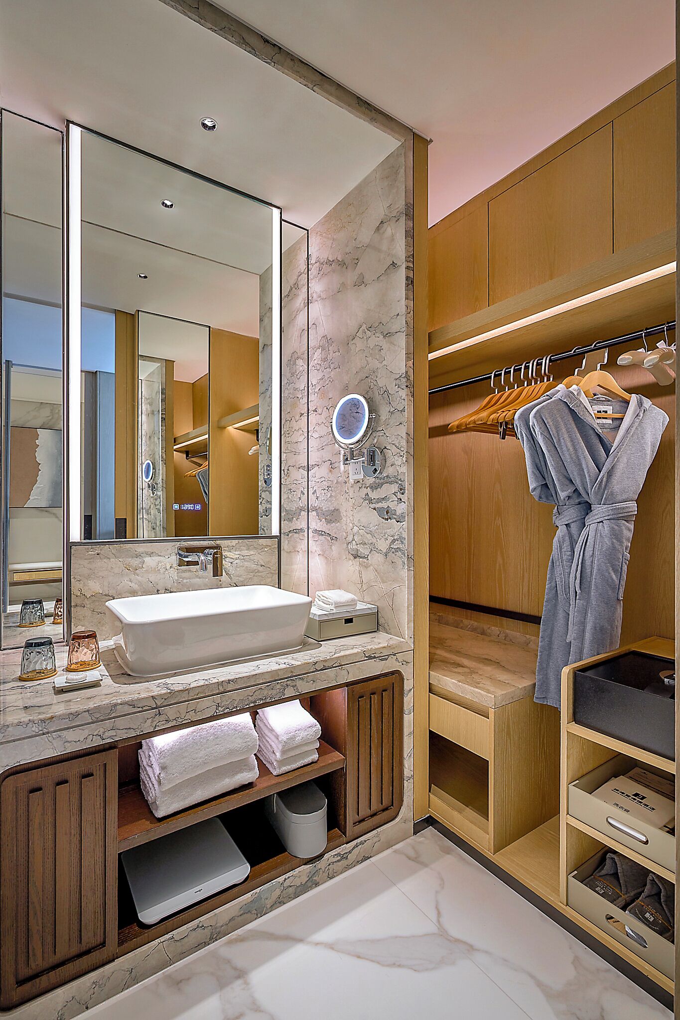 A modern bathroom with a large mirror, a sink, and a wooden vanity.