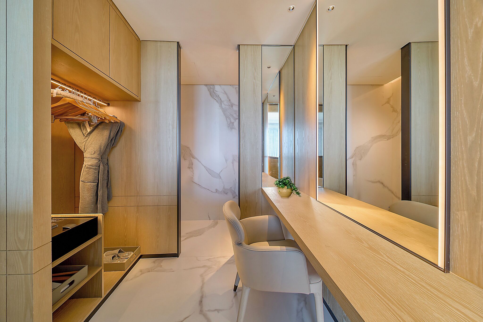 A modern bathroom with a marble floor, wooden vanity, and a large mirror.