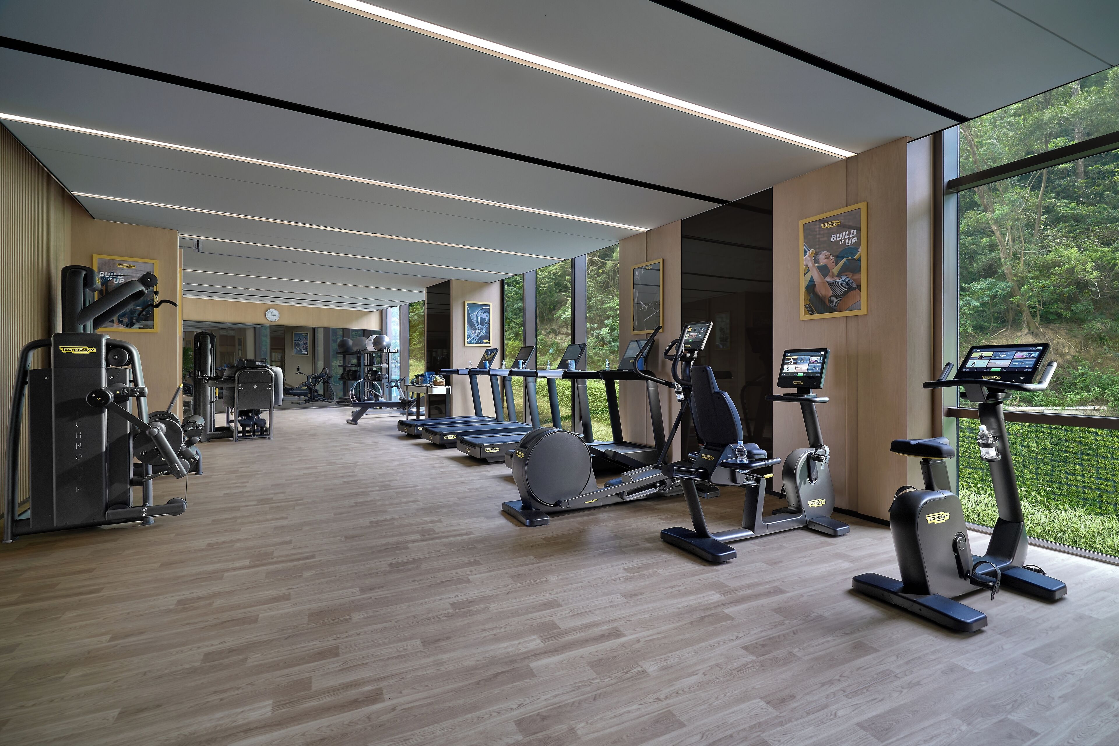 Una palestra con tapis roulant, ellittiche e attrezzi per pesi.