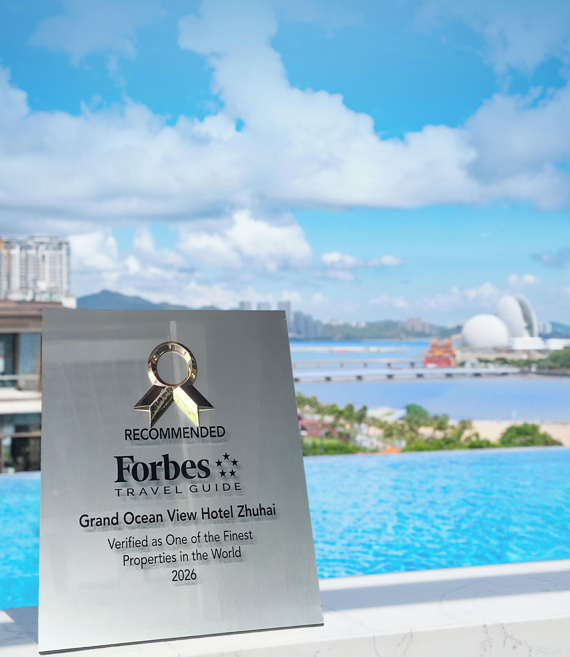 A hotel plaque with a ribbon symbol, indicating a recommendation by Forbes Travel Guide.
