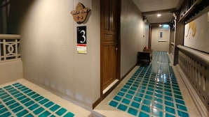 A hallway with a wooden door labeled "Gula Kwon 7-9" and a sign indicating "Floor 3". - The Boone Hotel (Chiang Mai)