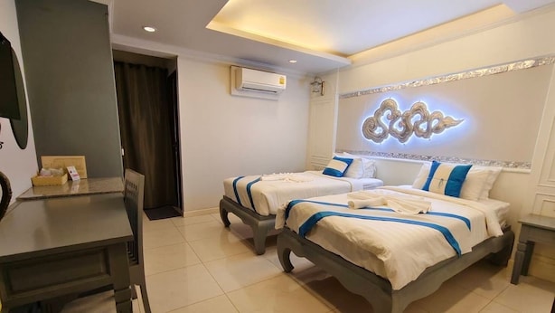 A hotel room with two beds, a desk, and a trash bin. - The Boone Hotel (Chiang Mai)