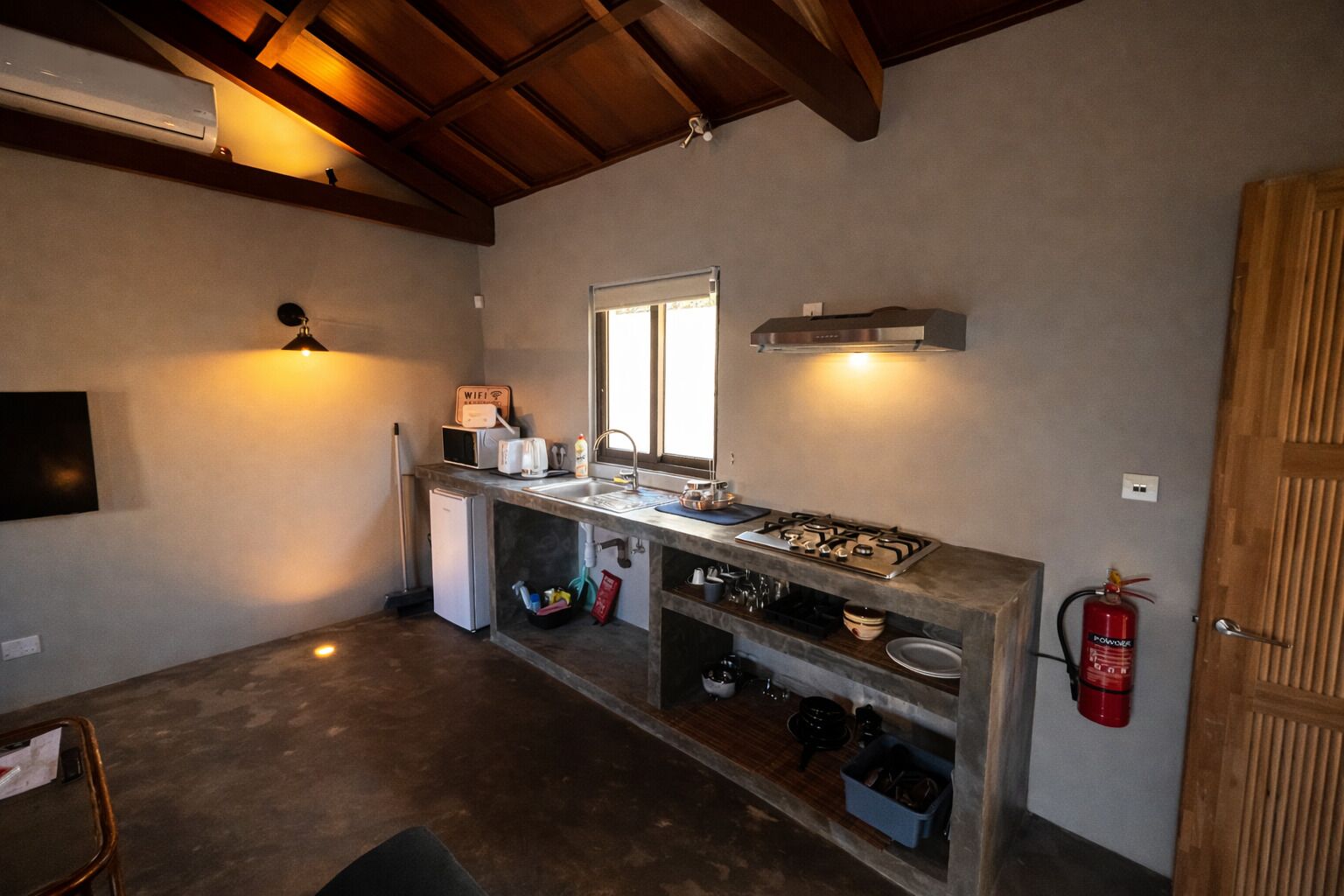 A compact kitchen with a built-in stove, a sink, and a window.