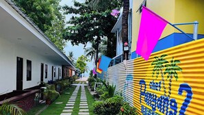 A pathway leading to a building with a colorful mural and a palm tree. - Chef Panyang Beach Resort 2 Okoy (Santa Fe)