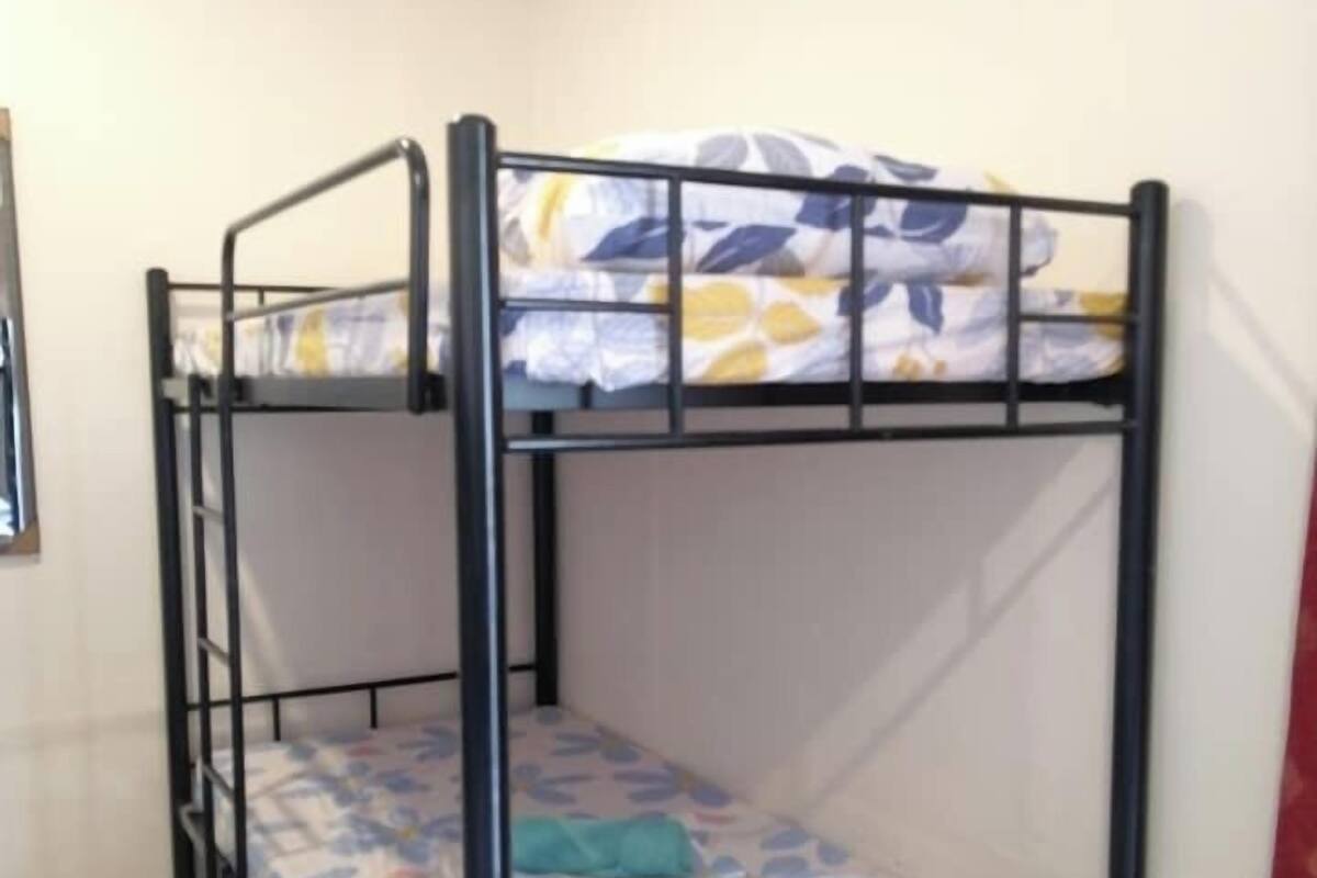 Una cama litera con un colchón estampado con motivos florales en una habitación de paredes lisas.