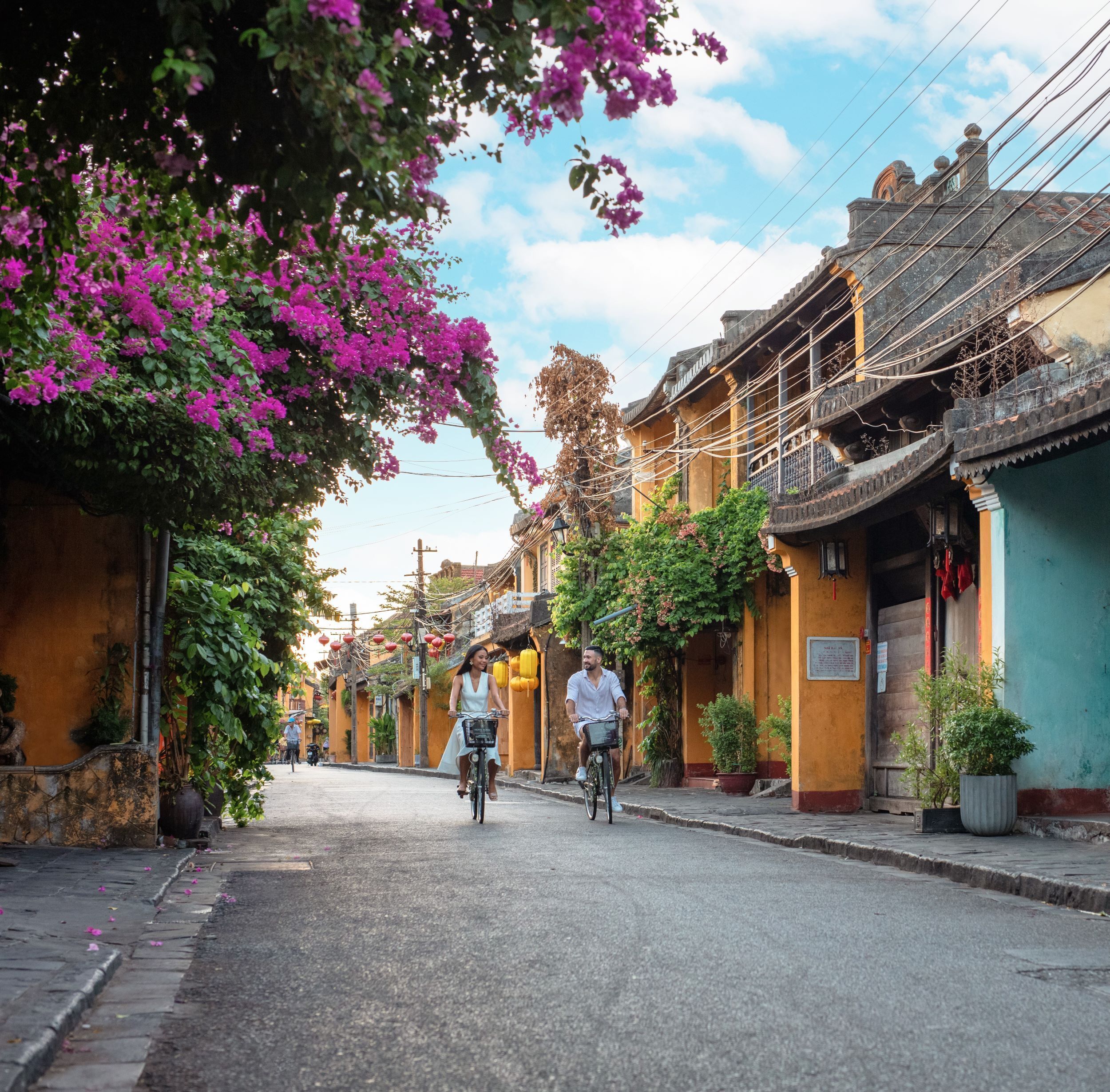 A narrow street lined with traditional buildings, some with balconies and decorative elements.