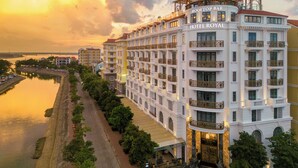 Un hotel de varios pisos con balcones, un bar en la azotea y vistas al río.