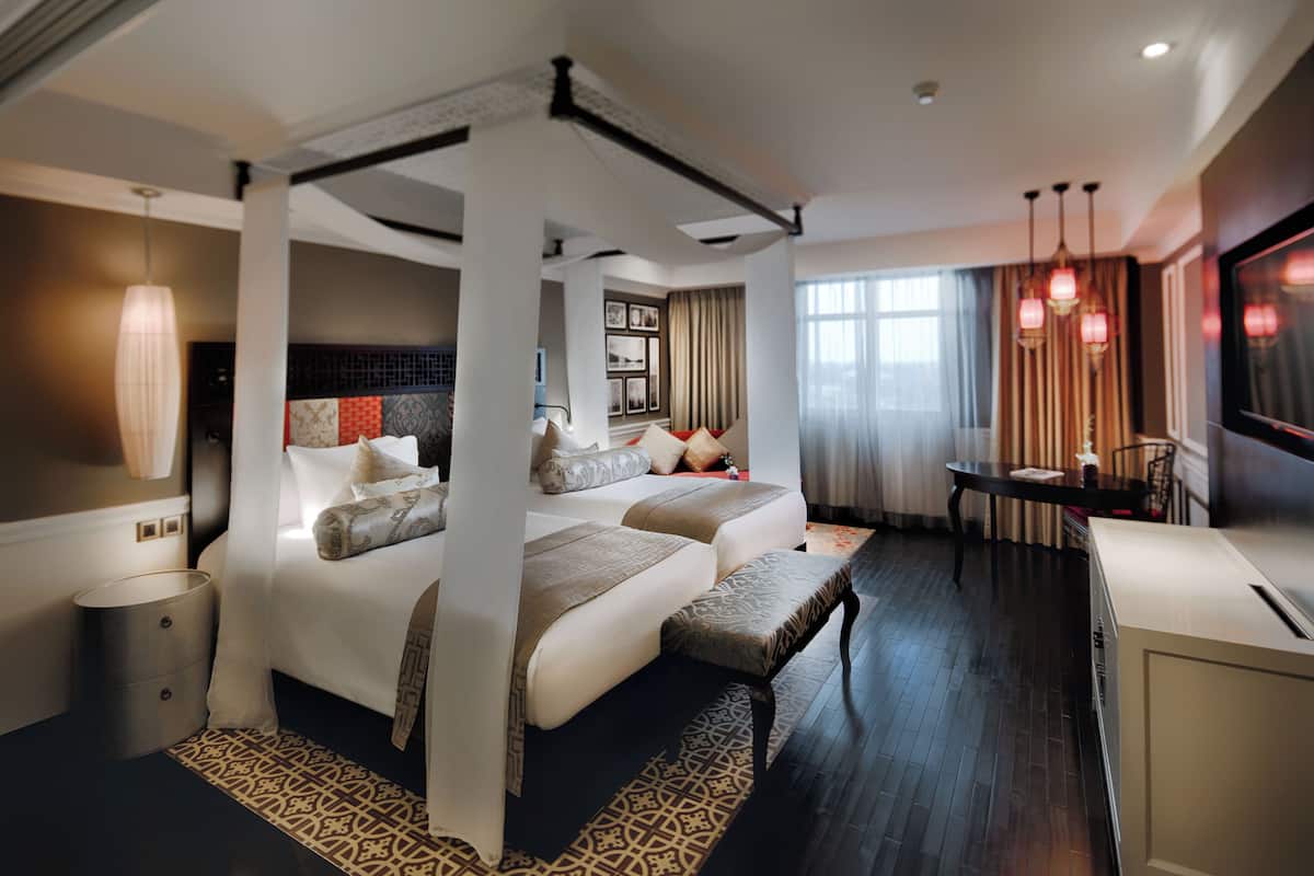 Una habitación de hotel moderna con una cama grande, un escritorio y vistas a la ciudad.