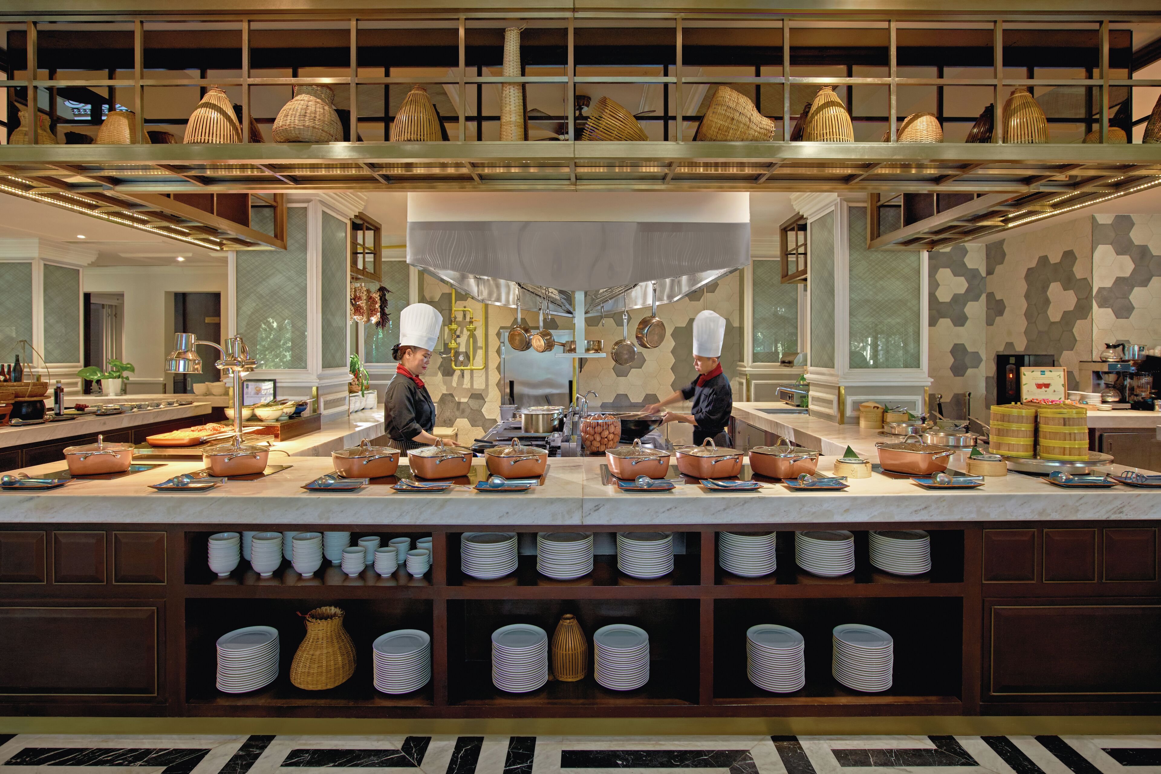 Un buffet avec plusieurs points de service, une grande variété de plats et un large choix de bols et d’assiettes.