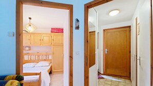 Ein Zimmer mit einem Bett, Holzschränken und einem Spiegel.