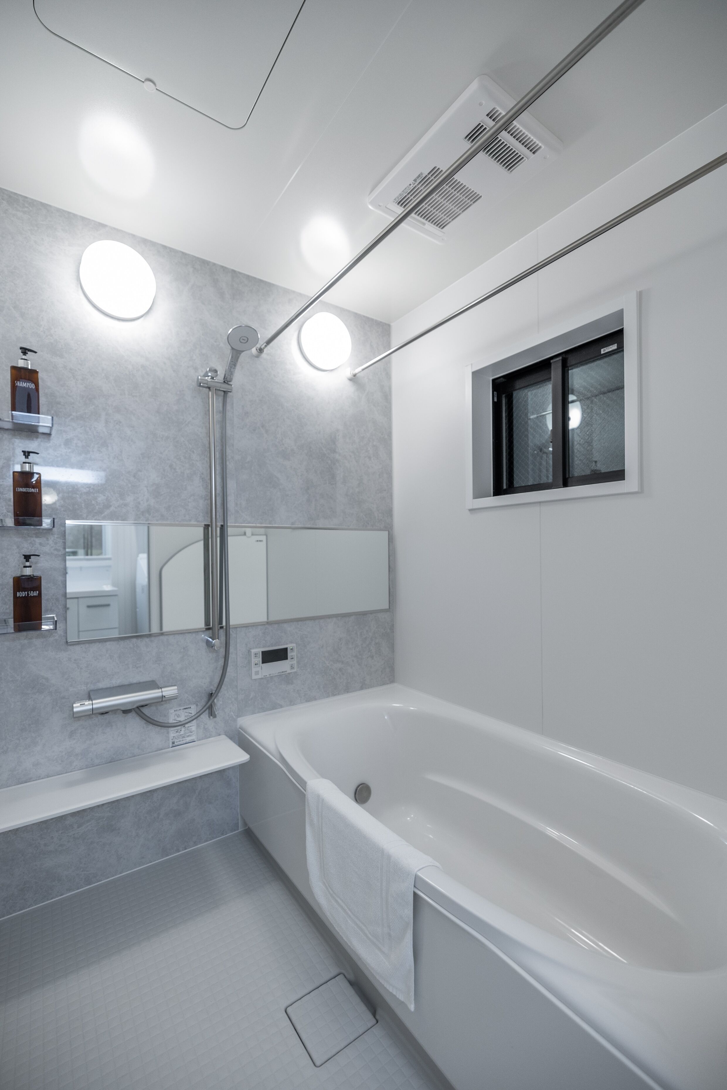 Un baño moderno con bañera, ducha, tocador con espejo e iluminación integrada.