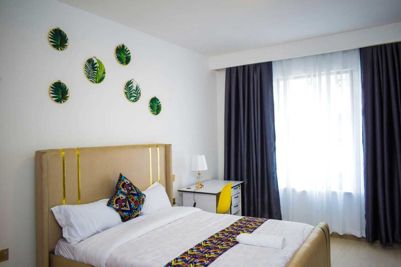 Une chambre d’hôtel avec un lit, un bureau et une fenêtre avec des rideaux.