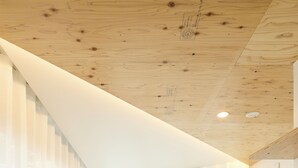 Una cocina moderna con detalles de madera, un amplio ventanal y un lavamanos integrado.