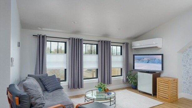 A modern living room with a grey sofa, a glass coffee table, and a flat-screen TV. - Downtown Denver Guesthouse  Near RiNo (Denver)