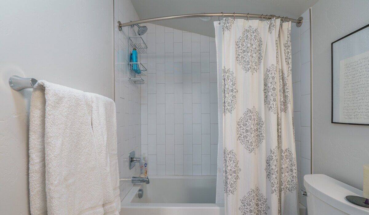 A bathroom with a shower, a bathtub, and a toilet.
