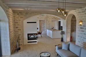 Relax in this open living area with a modern sofa, dining space, and kitchen counter.