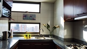 A kitchen with a window, a sink, and a vase with flowers. - Charming 1-bedroom apartment in Concepción with WiFi access (Concepción)