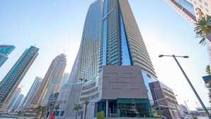 A high-rise building with a modern architectural design, featuring a prominent curved facade and multiple balconies. - FIRST CLASS | 1BR | Amazing Marina Views (Marina)
