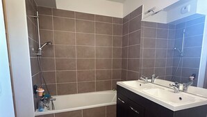 A modern bathroom with a bathtub, a shower, and a vanity with a mirror. - Top floor luxury apartment in a secure residence  (Châteauneuf-le-Rouge)