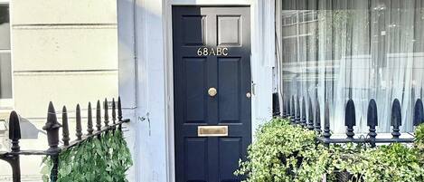 A black door with the number '68ABC' on a building labeled 'ALDERNEY STREET SW1' in the City of Westminster.