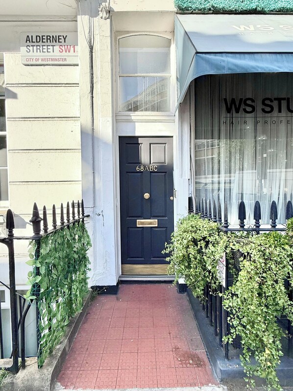 A black door with the number '68ABC' on a building labeled 'ALDERNEY STREET SW1' in the City of Westminster.