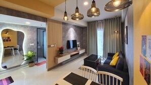 A modern living room with a sofa, a coffee table, and hanging pendant lights. - Soho Residence-Tony Apartment (Ho Chi Minh City)