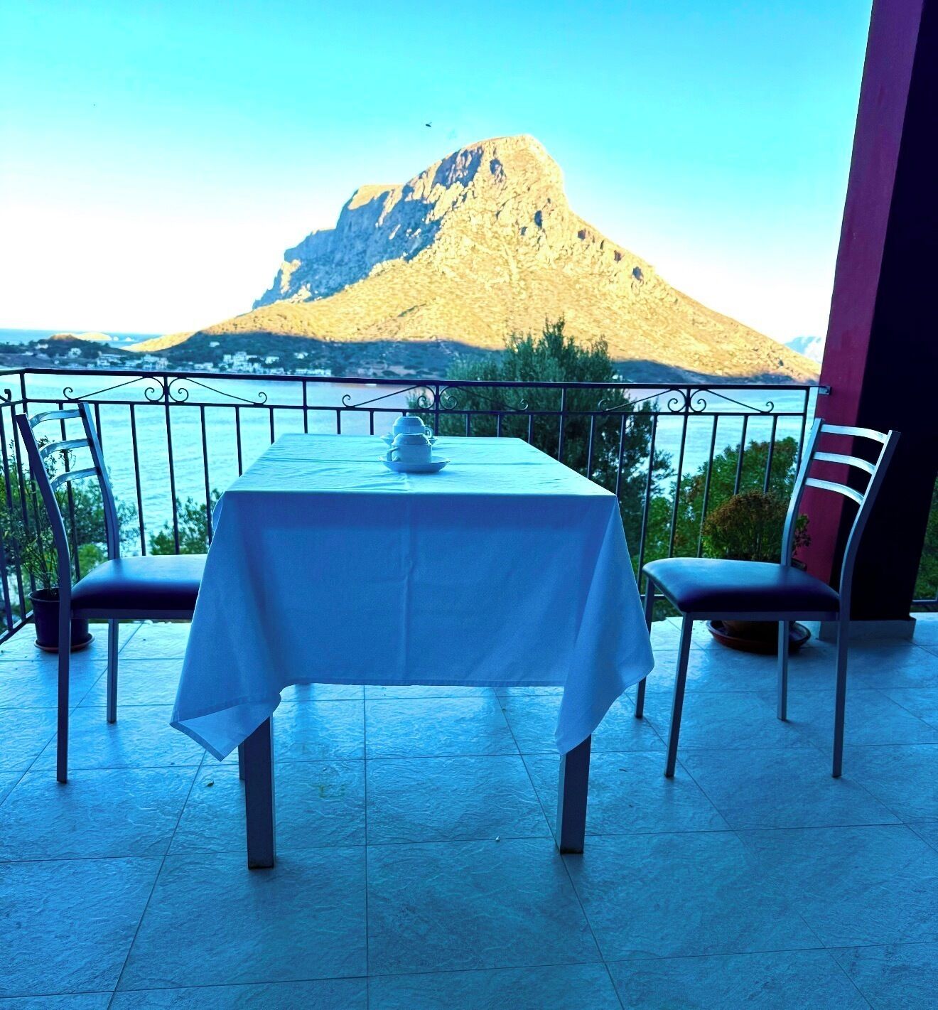 A table set on a balcony with a mountain view.
