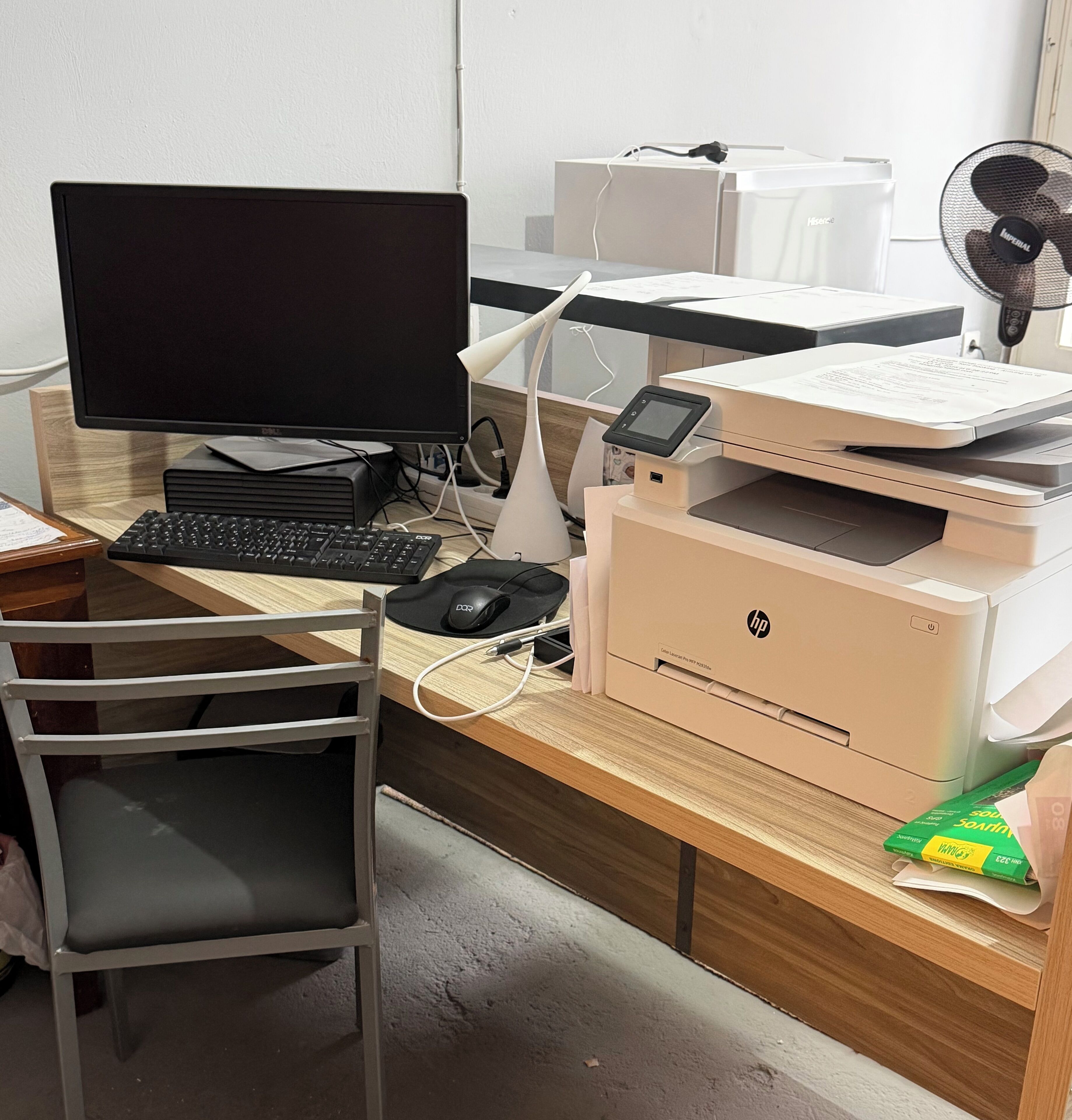 A workspace with a computer, monitor, keyboard, mouse, printer, and fan.