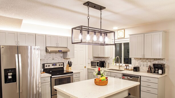 A modern kitchen with stainless steel appliances, a marble island, and a hanging light fixture. - Charming Retreat: King Bed, Full Kitchen & Spacious Backyard. Perfect Location! (Hillsboro)