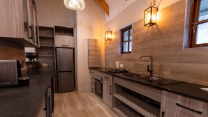 Una cucina moderna con mobili in legno, elettrodomestici in acciaio inossidabile e illuminazione integrata.
