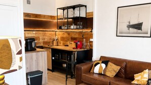 A modern living room with a brown leather sofa, a wooden coffee table, and a bookshelf.