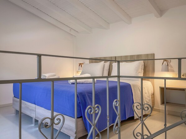 Una habitación de hotel con cama, mesitas de noche y barandilla.