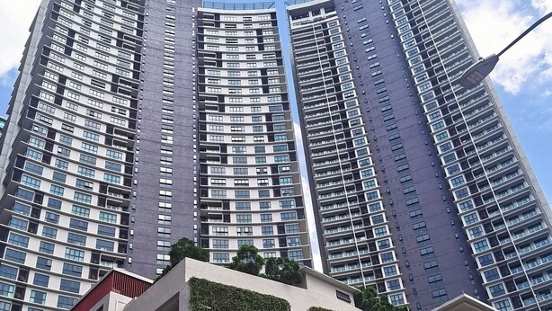 Un edificio alto con varios pisos, ventanas amplias y balcones.