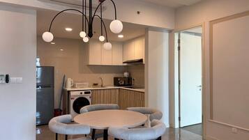 A modern kitchen with a round dining table and chairs, a built-in oven, and a microwave.