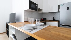 A modern kitchen with white cabinetry, a stainless steel refrigerator, and a microwave. - Italianway Comfort - Gallura 9 B (Milan)