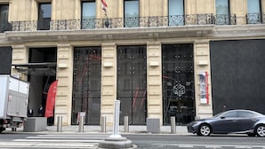 Un immeuble à plusieurs étages, de style architectural classique, caractérisé par des colonnes et des balcons richement décorés.