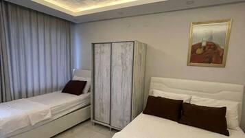 A hotel room with two beds, a wardrobe, and a ceiling with a geometric pattern.