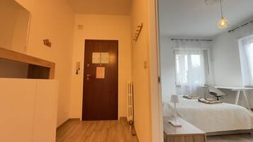 Una camera da letto con un letto, un comodino, una lampada e una scrivania con una sedia.