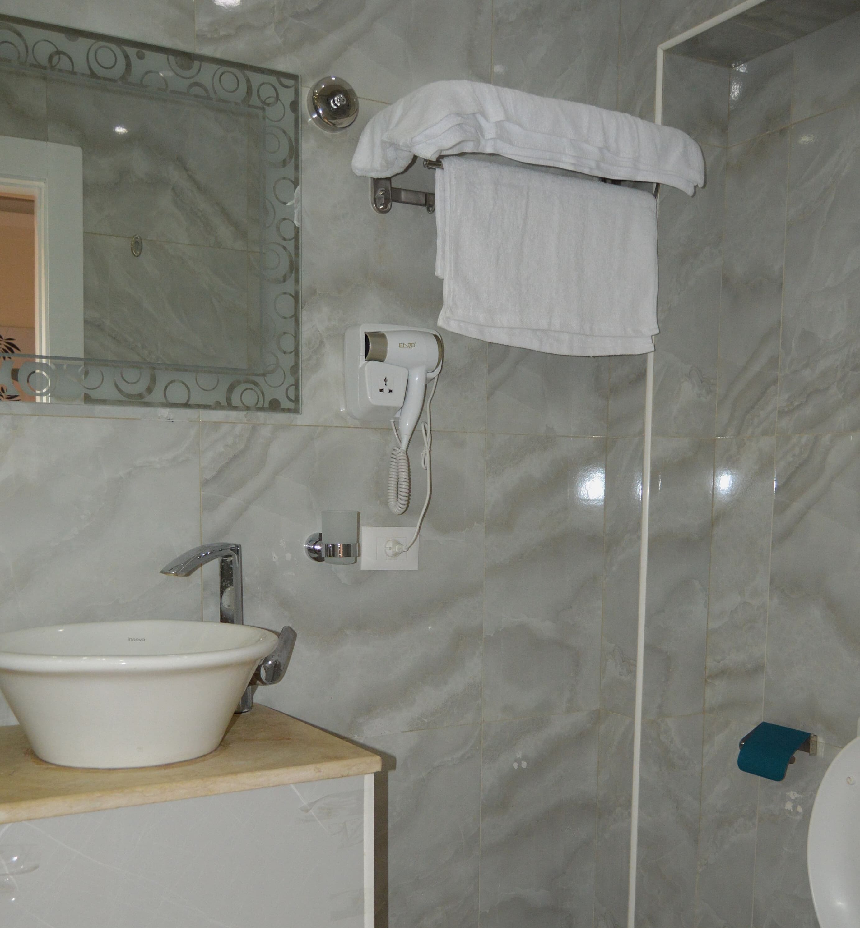 A bathroom with a sink, mirror, towel rack, and a hairdryer.
