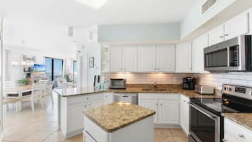 Condo com design assinado, vista para a praia | Cozinha privada | Geladeira, micro-ondas, fogão, cooktop
