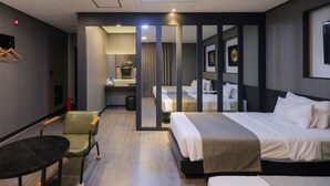 Een hotelkamer met een bed, een bureau, een stoel, een kleine tafel en een spiegel.