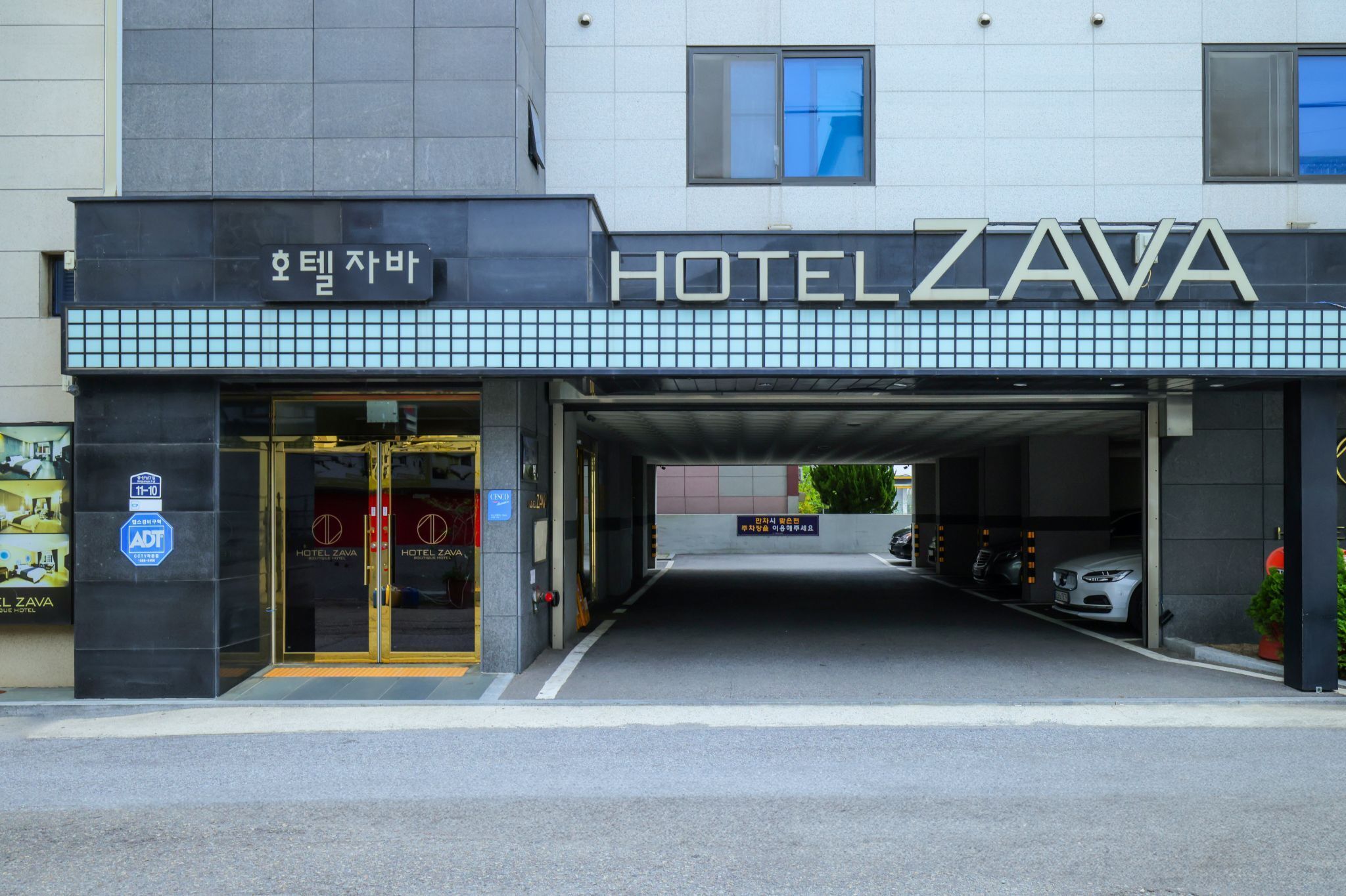 A hotel entrance with a modern design, featuring a large sign that reads "HOTEL ZAVA".