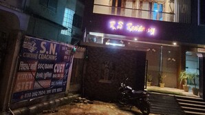 A multi-story building with illuminated signage, a motorcycle parked in front, and a gated entrance. - RS Residency By Wheels Hospitality (Varanasi)