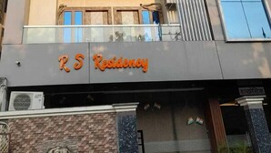 A multi-story building with balconies, a sign reading "RS Residency," and a brick facade. - RS Residency By Wheels Hospitality (Varanasi)